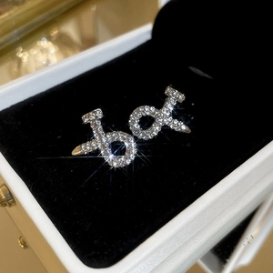 Macro shot of silver nail-shaped earrings with shimmering pave diamonds in a box