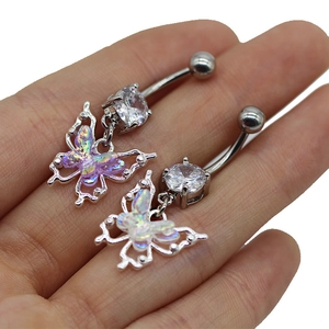 Détail de piercing nombril papillon aux ailes irisées et zircon cubique transparent