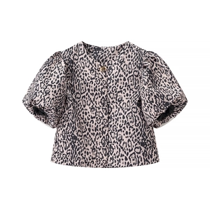 Detailed view of leopard print puff sleeves and gold button closure on a women shirt