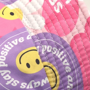 Detailed close-up of double-sided smiley print cotton fabric with precise stitching