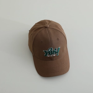 Detail of embroidered "YES! go to up" text on brown cotton baseball cap crown