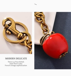 Detail of red apple keychain with antique bronze metal chain and lobster clasp connector