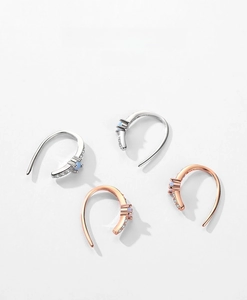 Macro detail of J-hook S925 sterling silver earrings with opal and zircon in rose gold and silver