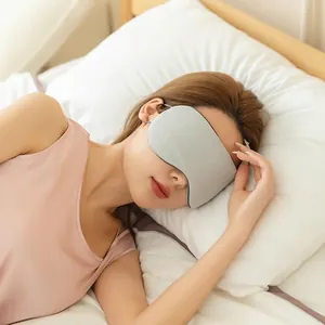 Ergonomic blackout sleep mask in grey knit fabric with adjustable strap on sleeping model