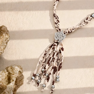 Détail de collier en tissu tissé avec pendentif rose en diamant et franges élégantes
