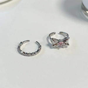Close-up of adjustable silver bow ring with pink zircon and micro-pave eternity band