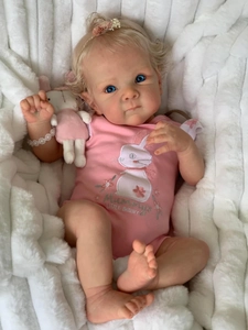 Detail of 18 inch realistic baby doll in pink bunny outfit with blonde hair and blue eyes