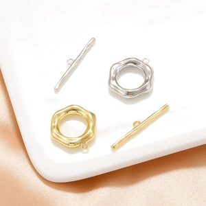 Detail view of 18K gold plated toggle clasps for necklaces on elegant silk fabric