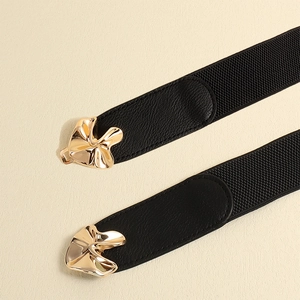 Detail of wide black elastic waist belt for women with elegant golden metal buckle