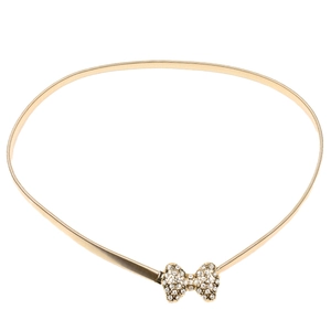 Détail d'une ceinture dorée élastique avec boucle en forme de nœud ornée de cristaux