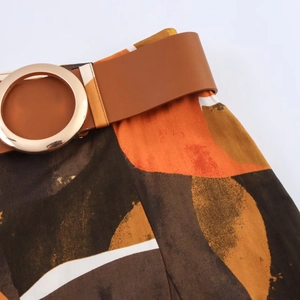 Detail van geprinte popeline rok met bruine leren riem en een ronde gouden gesp-sluiting
