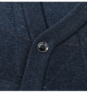Detailed close-up of a navy knit vest featuring a polished black button with silver trim