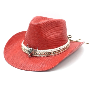 Red western straw cowboy hat with golden rivet band and silver bull head decoration