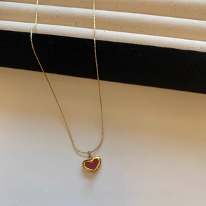 Minimalist gold titanium necklace with a heart pendant in deep red color for women