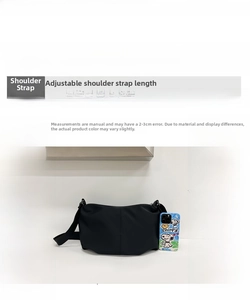 Detail view of black dumpling bag with adjustable strap and interior nylon lining material