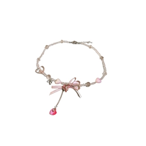 Sweet pink beaded choker featuring a ribbon bow and sparkling heart pendant on white background