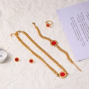 Detailed set of golden stainless steel necklace bracelet and rings with red circle charms