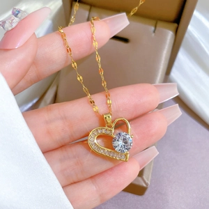 Detail of gold heart pendant necklace featuring large center stone and pavé crystal border