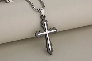 Close-up of gothic black and silver stainless steel cross pendant on a sturdy metal chain