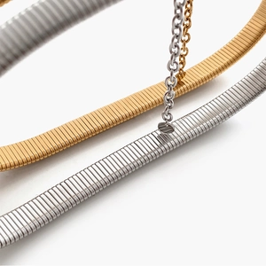 Macro shot of gold and silver flexible snake bone necklaces with fine metallic texture