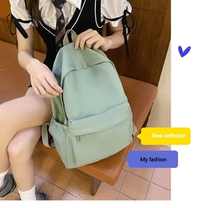 Detail view of mint green school backpack featuring waterproof fabric and side pocket
