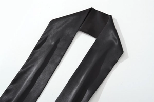 Détail du tissu en satin noir brillant de la robe bustier avec texture soyeuse