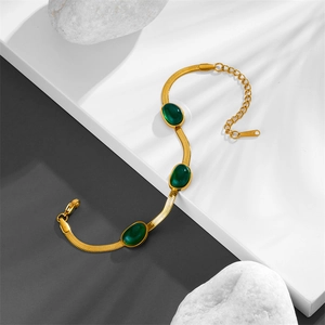 Dettaglio della collana a catena serpente dorata con cinque pietre ovali verde smeraldo