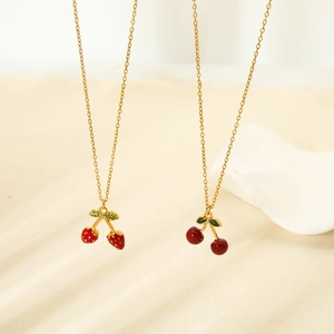 Detail view of 18K gold plated strawberry and cherry pendants on fine link chains