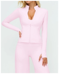 Détail des poignets passe-pouce et du tissu extensible de la veste de yoga rose