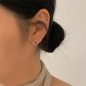 Close-up of heart-shaped 925 sterling silver stud earring with black enamel inlay