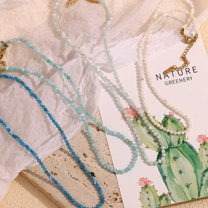 Detailed macro view of multi-colored natural stone beaded necklaces with 18K gold plated clasps