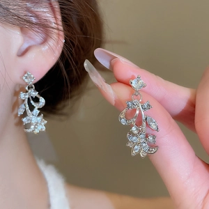 Close-up of elegant silver flower and leaf earrings set with sparkling rhinestones