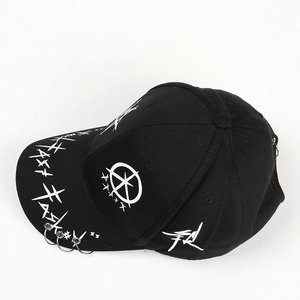 Detailed macro view of black cotton baseball cap with white graffiti art and three metal rings