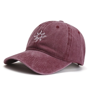 Burgundy washed cotton baseball cap with white sun embroidery and curved brim in side view