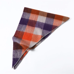 Detail showing the thick wool-like texture and overlock edge of the colorful plaid scarf
