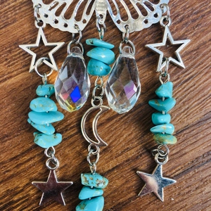 Macro shot of butterfly suncatcher with turquoise stones and crescent moon crystals