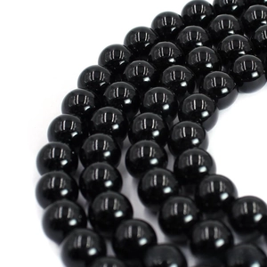 Macro shot of polished black agate round beads with reflective mirror finish for DIY jewelry