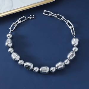 Detail of chunky silver beads and geometric links with lobster clasp on dark blue
