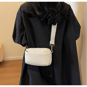 Detail of off-white lychee texture leather crossbody bag with geometric woven shoulder strap