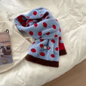 Close-up of blue plush scarf with red polka dots and soft brown faux fur trim details