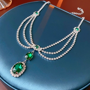 Close-up of elegant French style earrings with green oval gemstones and silver plating
