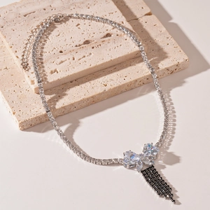 Detailed macro view of silver zircon butterfly pendant with black gemstone tassels