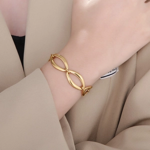 Macro detail of gold-plated geometric link bracelet on wrist with elegant hollow oval rings