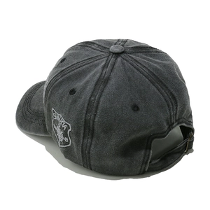 Detail of washed cotton baseball cap featuring side embroidery and adjustable metal buckle