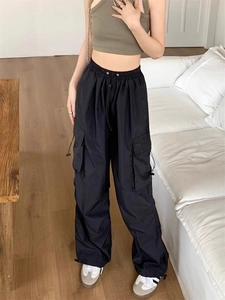Detail of black cargo pants with large side pockets and adjustable drawstring waist