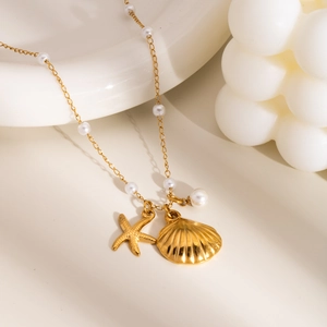 Detail view of gold titanium necklace with white pearls, starfish and shell pendants
