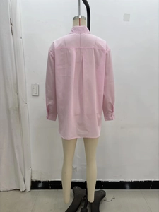 Détail du dos d'une chemise en coton rose avec pli central exposé sur un mannequin de couture