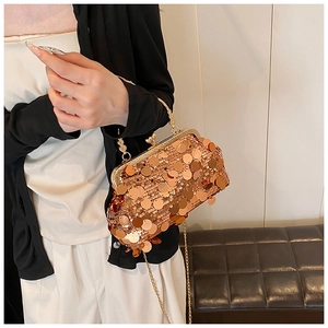 Detail of elegant gold sequin evening bag featuring metal frame and luxury chain strap