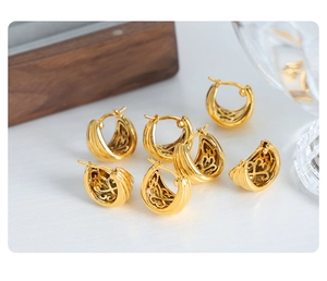 Close-up of gold U-shaped earrings featuring vintage hollow patterns and ribbed texture