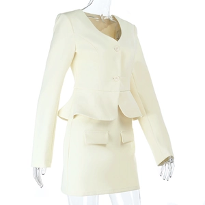 Detail of off-white skirt suit with ruffled blazer hem and decorative flap pockets